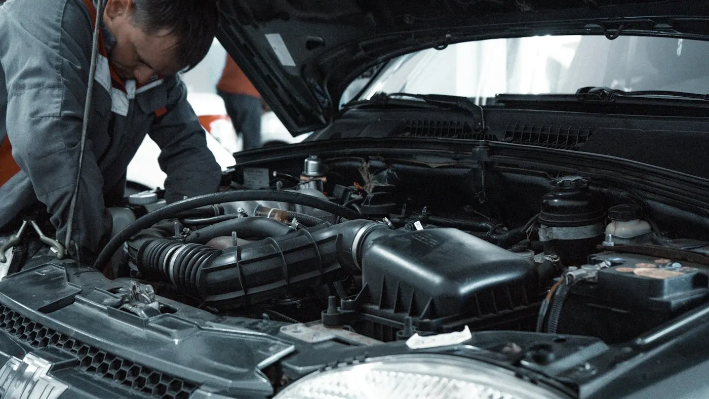 Profissional avaliando o compartimento do motor de um veículo